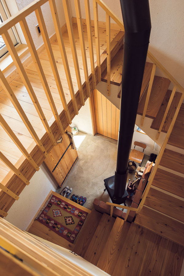 玄関から入ってすぐの土間に薪ストーブを置き、料理にも利用。暖かい空気は階段を介して2階へも